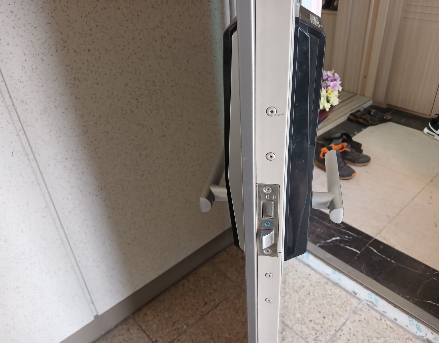 구로구 개봉동 출장 — 열린 문 옆면의 은색 걸쇠 판과 양쪽에 달린 검은 본체, 은색 손잡이